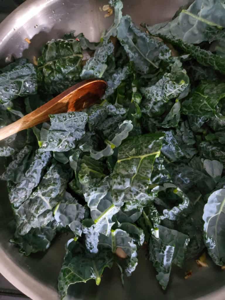 Sauteed Kale and Mushrooms- kale in pan with wooden spoon